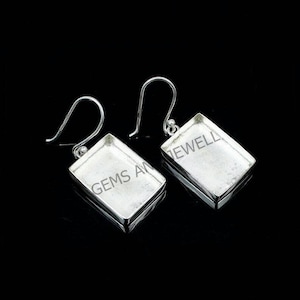 May include: A pair of silver earrings with rectangular settings. The earrings have a simple design and are perfect for everyday wear.
