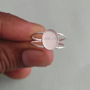May include: Silver ring with a blank oval bezel setting. The ring is designed to hold a cabochon stone or other embellishment.