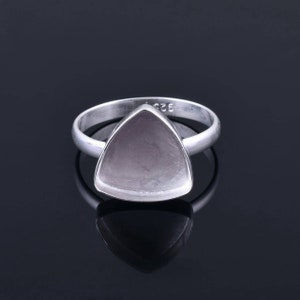 May include: A silver ring with a triangular shaped setting. The setting is empty and ready to be filled with a gemstone.