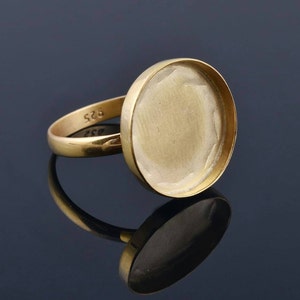 Puede incluir: Un anillo de oro con un engaste redondo y vacío. El anillo está marcado con "925" en la banda.