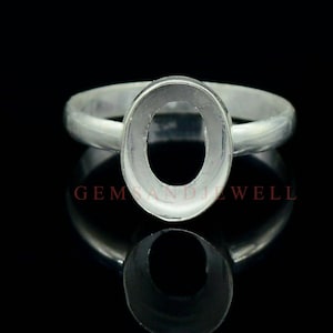 May include: Silver ring with an oval-shaped bezel setting. The ring is designed to hold a gemstone or other material.