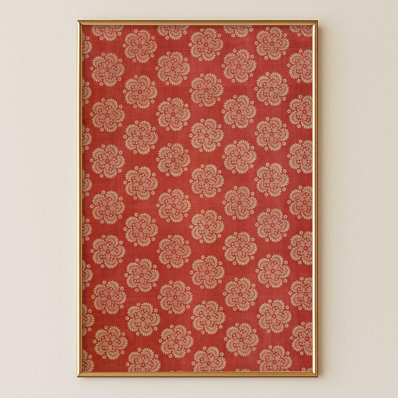 Red antique Indian block print floral artwork with repeat folk floral medallion pattern in vermillion and beige tones in a sleek wood frame on a soft warm cream wall