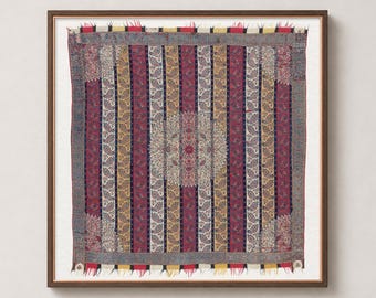 May include: A square textile wall hanging framed in wood, featuring a central circular medallion surrounded by vertical stripes in shades of red, yellow, blue, and cream. The fabric displays intricate paisley patterns and frayed edges.