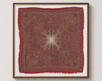 May include: A square textile piece featuring a deep red background with an intricate, multi-colored paisley pattern in shades of gold, blue, and cream. The fabric has a frayed, raw edge and is displayed within a dark brown wooden frame.