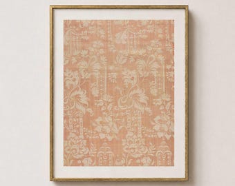 May include: A rectangular wall art piece featuring a peach-colored fabric with a cream-colored floral damask pattern, encased in a thin, metallic gold frame with a white mat border surrounding the central textile print.