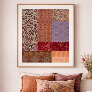 Puede incluir: Una obra de arte enmarcada con un mosaico de muestras de tela estampada en tonos de rojo, morado, naranja y dorado. La obra de arte se exhibe sobre una cama con almohadas decorativas en colores complementarios.