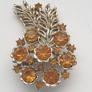 Vintage gold tone bouquet style brooch with stunning amber toned rhinestones.
