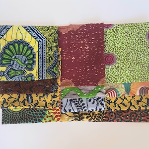 Puede incluir: Una colección de retazos de tela en varios patrones y colores, incluyendo amarillo, verde, marrón y rojo. Las telas presentan diseños geométricos y florales.