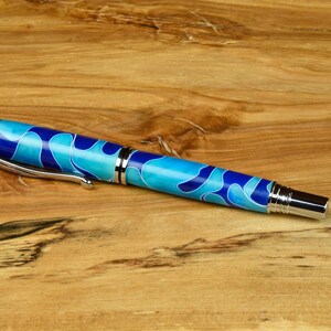 Rollerball pen with light and dark blue barrels with chrome & black hardware and a postable cap