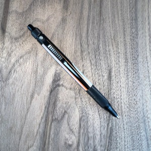 Everyday Carry balpen met klikpen met zwart geanodiseerde aluminium fittingen. Barrel heeft diep oranje, taupe en zwart.