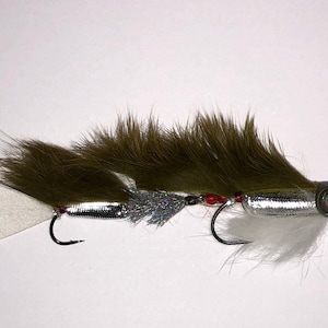 May include: A brown and silver fly fishing lure with white feathers and red beads.
