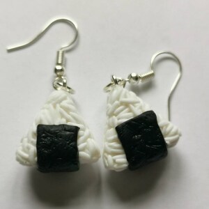 K&ouml;nnte beinhalten: Ein Paar silberne Ohrh&auml;nger mit wei&szlig;en und schwarzen Onigiri aus Ton, einem japanischen Reisball.