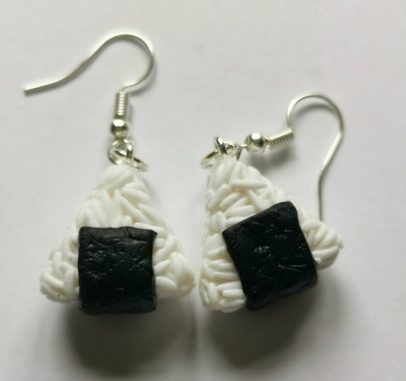 K&ouml;nnte beinhalten: Ein Paar silberne Ohrh&auml;nger mit wei&szlig;en und schwarzen Onigiri aus Ton, einem japanischen Reisball.