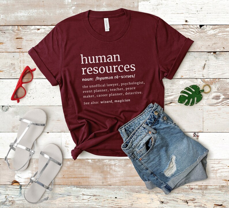 May include: A maroon t-shirt with the words "human resources" printed in white. The definition includes a list of related professions. The shirt is paired with denim shorts, silver sandals, and red sunglasses.