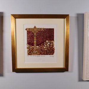 May include: A framed print of a colorful abstract artwork depicting a cross-shaped structure with a red background. The artwork is surrounded by a gold frame and a white mat.