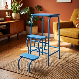 May include: A bright blue metal step stool featuring a tall frame with a top platform, a middle step, and a lower step. The structure is composed of tubular metal legs and flat rectangular surfaces for each level, providing a stable design.