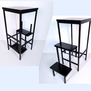 May include: Black metal step stool with three steps. The top step is a platform, and the bottom two steps are individual steps.