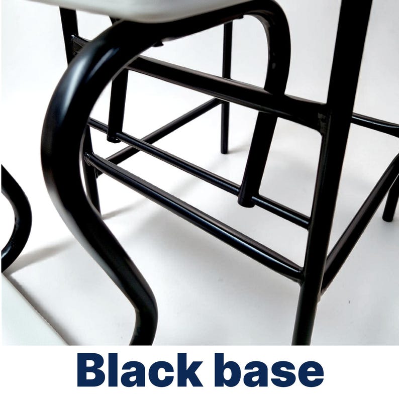 Op de afbeelding: Close-up van een zwart metalen stoelonderstel. De basis heeft gebogen poten en een netwerk van rechte steunstaven. De tekst "Black base" wordt in een donkerblauwe lettertype onderaan de afbeelding weergegeven.
