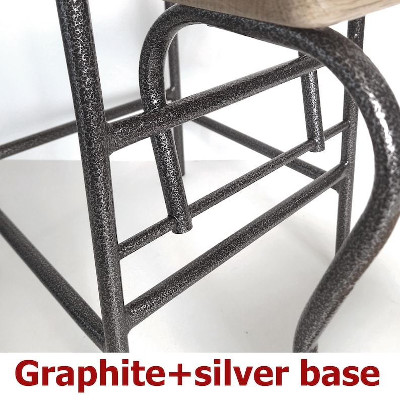 Op de afbeelding: Close-up van een grafiet en zilver metalen stoelbasis. Het metalen frame heeft een getextureerde afwerking en gebogen poten. De tekst "Graphite+silver base" staat onderaan de afbeelding.