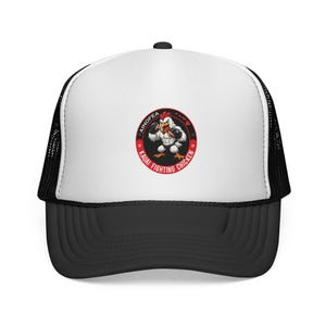 Peut inclure: Une casquette trucker blanche et noire avec un motif circulaire sur le panneau avant. Le motif représente un poulet blanc musclé portant des gants de boxe noirs, entouré du texte AINOFEA KAUAI FIGHTING CHICKEN dans une bordure rouge.