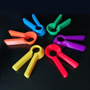 May include: Six colorful bottle openers in a rainbow pattern. The openers are made of plastic and have a simple design.