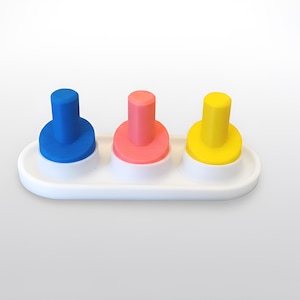 May include: A white plastic toy with three colorful pegs: blue, pink, and yellow. Each peg is cylindrical with a circular base, set on a white, oval-shaped platform. The pegs are evenly spaced and stand upright.