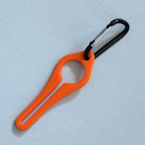 Puede incluir: Un llavero de pl&aacute;stico naranja con un mosquet&oacute;n. El llavero tiene un bucle en un extremo y un extremo puntiagudo en el otro.