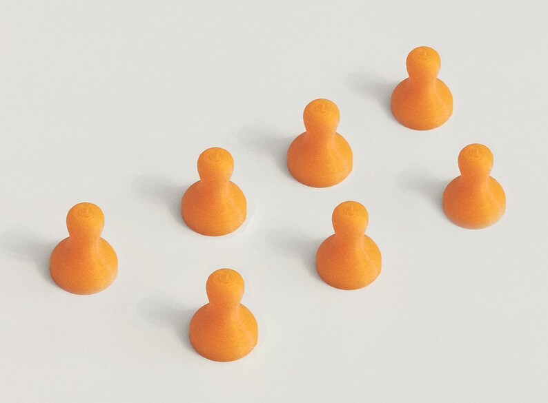 May include: Seven orange, abstract-shaped game pieces are arranged on a white surface. Each piece has a rounded base and a smaller, rounded top. The pieces are evenly spaced, creating a visually appealing pattern.