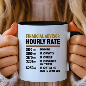 May include: White ceramic mug with a black interior and handle, featuring the text "FINANCIAL ADVISOR HOURLY RATE" in gold and black. The mug lists hourly rates for different levels of involvement, from minimum to telling the advisor how to do their job.