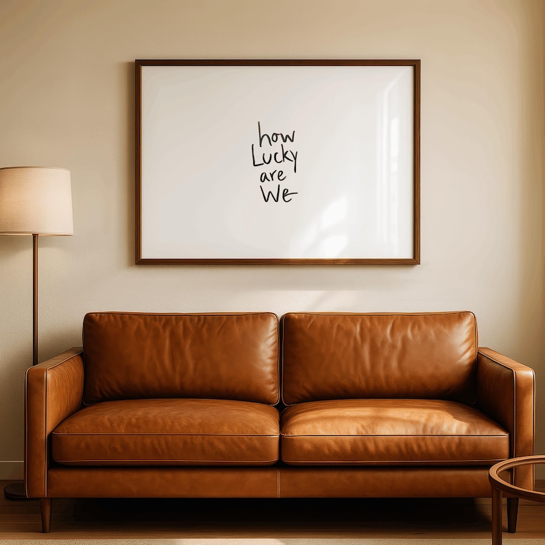 A minimalist wall art print featuring the quote “How Lucky Are We” in elegant hand-drawn typography on a neutral background. The modern canvas design exudes warmth and simplicity, perfect for couples who value love and gratitude. This inspirational quote poster adds a timeless touch to any contemporary or boho-style home. A beautifully crafted neutral wall decor piece that symbolizes appreciation, connection, and modern elegance.