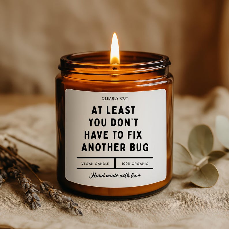 Peut inclure: Une bougie allum&eacute;e dans un pot en verre ambr&eacute; avec une &eacute;tiquette blanche portant l'inscription : CLEARLY CUT, AT LEAST YOU DON'T HAVE TO FIX ANOTHER BUG, VEGAN CANDLE, 100% ORGANIC, Hand made with love. La bougie a une flamme unique.