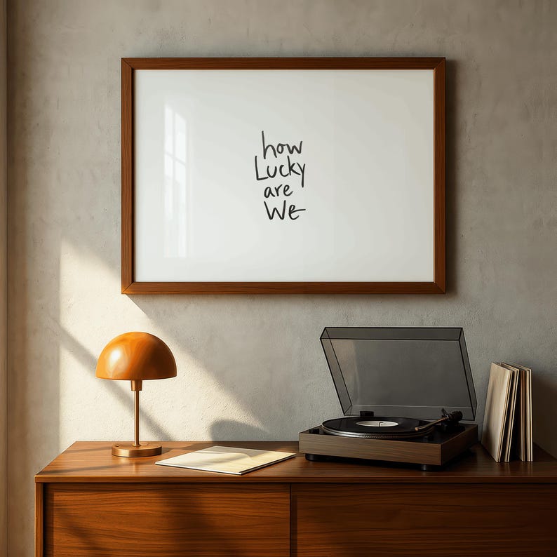 A minimalist wall art print featuring the quote “How Lucky Are We” in elegant hand-drawn typography on a neutral background. The modern canvas design exudes warmth and simplicity, perfect for couples who value love and gratitude. This inspirational quote poster adds a timeless touch to any contemporary or boho-style home. A beautifully crafted neutral wall decor piece that symbolizes appreciation, connection, and modern elegance.