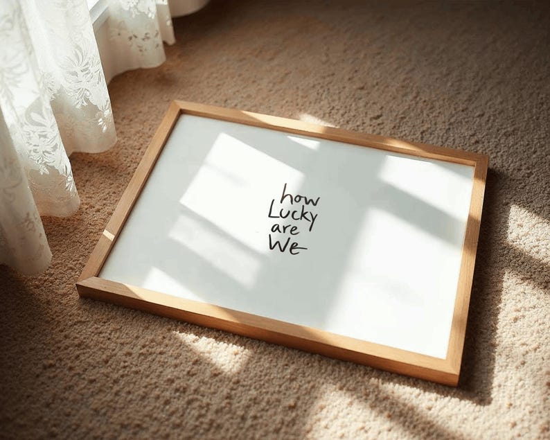 A minimalist wall art print featuring the quote “How Lucky Are We” in elegant hand-drawn typography on a neutral background. The modern canvas design exudes warmth and simplicity, perfect for couples who value love and gratitude. This inspirational quote poster adds a timeless touch to any contemporary or boho-style home. A beautifully crafted neutral wall decor piece that symbolizes appreciation, connection, and modern elegance.