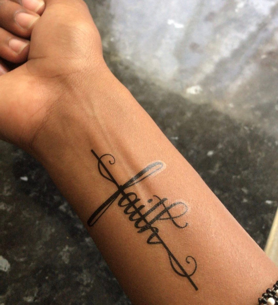 Faith cross tattoo handwritten on the inner arm