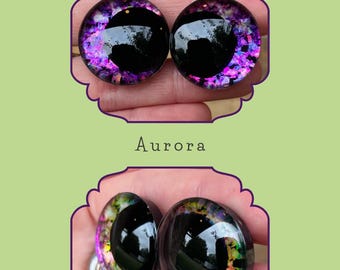 Puede incluir: Dos pares de ojos de vidrio negro con acentos iridiscentes morados y verdes. Los ojos son para manualidades y la fabricación de muñecas.