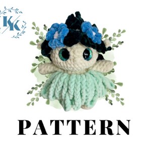 May include: Crochet pattern for a small, white amigurumi doll with blue flowers in her hair and a mint green skirt. The doll has large, sparkly eyes and a black and white striped headband.
