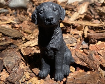 Figura de cemento de un labrador retriever negro hecha a mano
