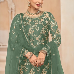 Op de afbeelding: Een groene geborduurde jurk met een bijpassende, doorschijnende dupatta. De jurk heeft een bloemenmotief en is versierd met gouden borduurwerk. De dupatta is doorschijnend en heeft een gouden rand. De jurk is een traditioneel Indiaas kledingstuk en perfect voor speciale gelegenheden.