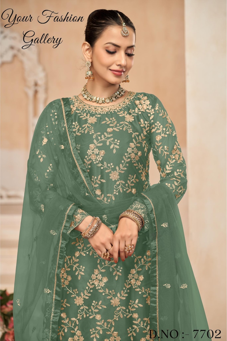 Op de afbeelding: Een groene geborduurde jurk met een bijpassende, doorschijnende dupatta. De jurk heeft een bloemenmotief en is versierd met gouden borduurwerk. De dupatta is doorschijnend en heeft een gouden rand. De jurk is een traditioneel Indiaas kledingstuk en perfect voor speciale gelegenheden.