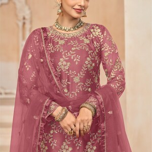 Op de afbeelding: Een roze geborduurde jurk met een bijpassende, doorschijnende dupatta. De jurk heeft een ronde hals en lange mouwen. De dupatta is versierd met een bloemenpatroon. D.NO: 7701