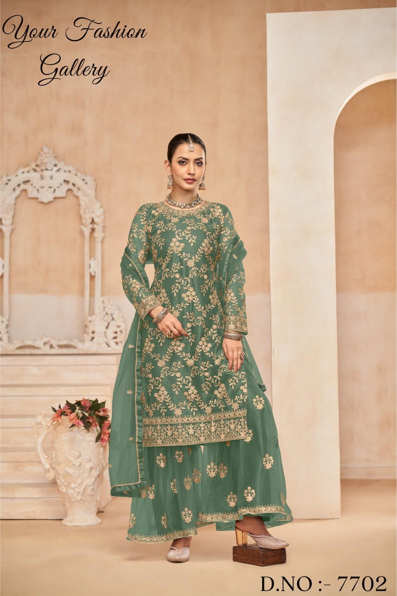Op de afbeelding: Een groene geborduurde jurk met een bijpassende dupatta en palazzo broek. De jurk heeft een ronde halslijn en lange mouwen. De stof is doorschijnend en heeft een bloemenpatroon. De jurk is versierd met gouden borduurwerk. De outfit is perfect voor een speciale gelegenheid.