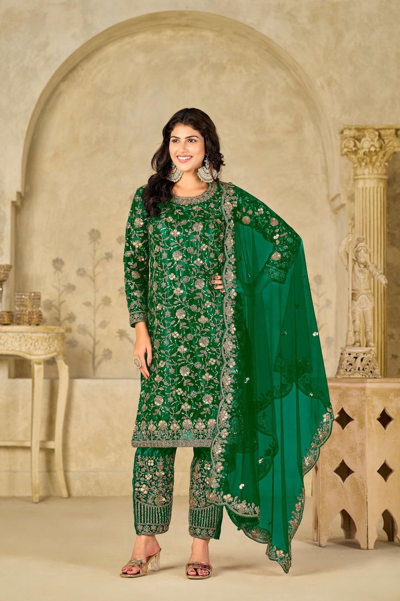Pu&ograve; includere: Un completo salwar kameez verde smeraldo intenso composto da una tunica a maniche lunghe e pantaloni abbinati, entrambi decorati con intricati ricami floreali dorati e paillettes. &Egrave; incluso un dupatta verde trasparente con bordo smerlato ricamato.