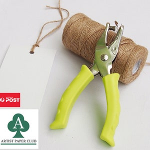 May include: A lime green hand-held paper punch with a silver metal punch head. The punch is on top of a roll of brown twine.