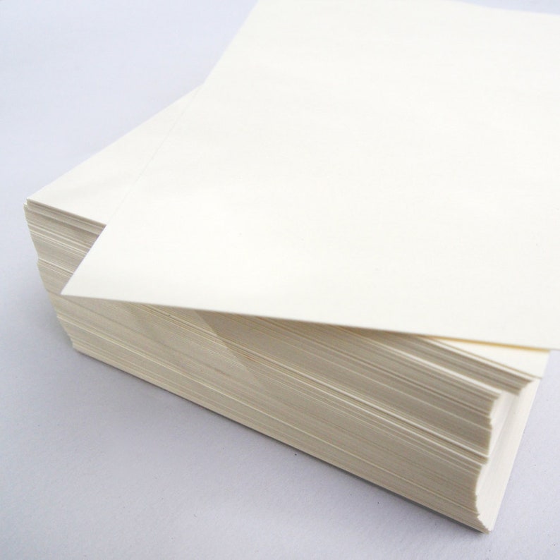 May include: A stack of white paper sheets, with the top sheet folded over the edge of the stack.