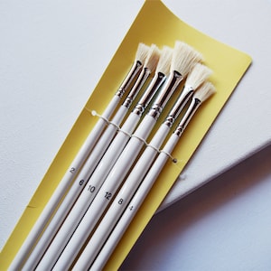 May include: Set of six white paint brushes with yellow handles. The brushes are labeled with numbers 2, 6, 10, 12, 8, and 4.