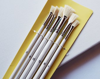 May include: Set of six white paint brushes with yellow handles. The brushes are labeled with numbers 2, 6, 10, 12, 8, and 4.