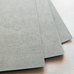 May include: Four sheets of gray textured paper with a wood grain pattern.
