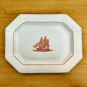 May include: White rectangular serving platter with a red illustration of a tall sailing ship. The platter has a red border and a decorative octagonal shape. A nautical themed serving dish.