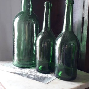 Antiguas botellas de cristal.  Botella grande de cristal verde esmeralda. Botellas de cidra y vino español. Botella de vidrio verde vintage.