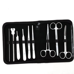 May include: A black zippered case containing various surgical instruments. The instruments include scalpels, forceps, scissors, and other tools, all made of shiny, silver-colored metal. The case is open, displaying the tools neatly arranged against a black interior.